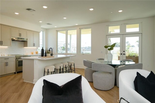 414 Main Unit 200, Huntington Beach, CA 92648 - kitchen featuring high end stainless steel range, under cabinet range hood, plenty of natural light, light countertops, and recessed lighting