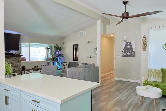 6683 Ballinger Ave, San Diego, CA 92119 - kitchen featuring open floor plan, a ceiling fan, a stone fireplace, light countertops, and light wood finished floors