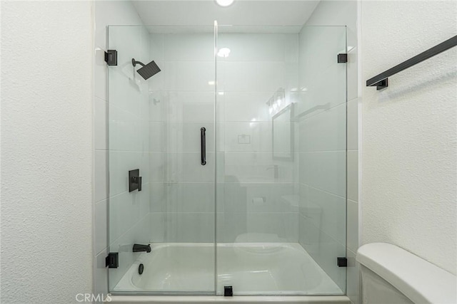 1108 Camino Real Unit 306, Redondo Beach, CA 90277 - bathroom featuring toilet, bath / shower combo with glass door, and a textured wall