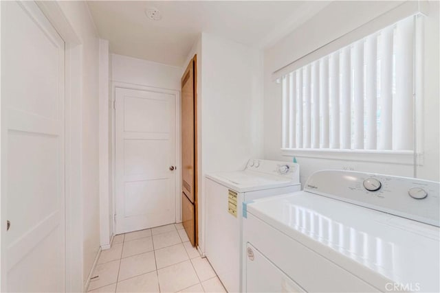 laundry room featuring washing machine and dryer and light tile patterned flooring