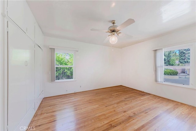 spare room with light wood-type flooring and ceiling fan