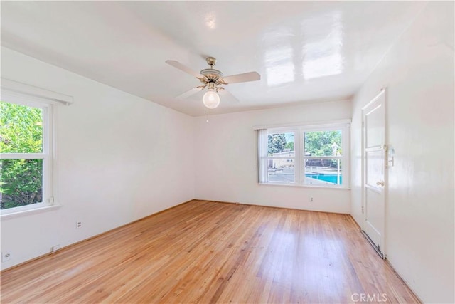 spare room with light wood-type flooring and a ceiling fan