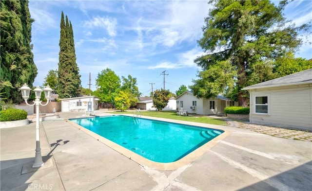 swimming pool featuring a patio and an outbuilding