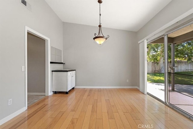 168 Radford Ct, Riverside, CA 92507 - unfurnished dining area featuring light wood-style floors, baseboards, and vaulted ceiling