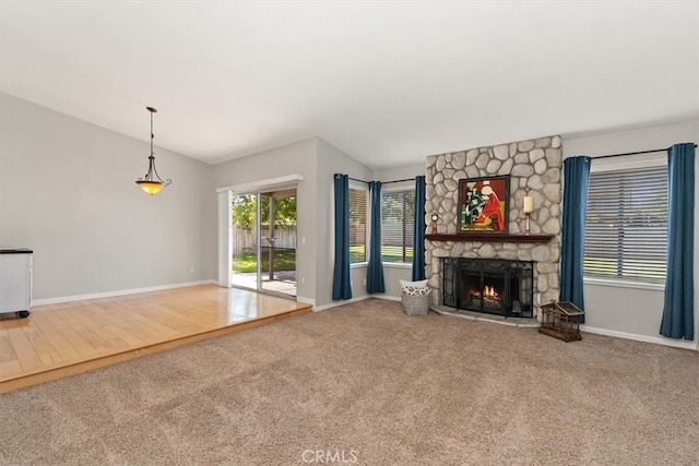 168 Radford Ct, Riverside, CA 92507 - unfurnished living room with lofted ceiling, carpet floors, a stone fireplace, and baseboards