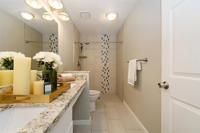 168 Radford Ct, Riverside, CA 92507 - bathroom featuring toilet, tiled shower, tile patterned flooring, vanity, and baseboards
