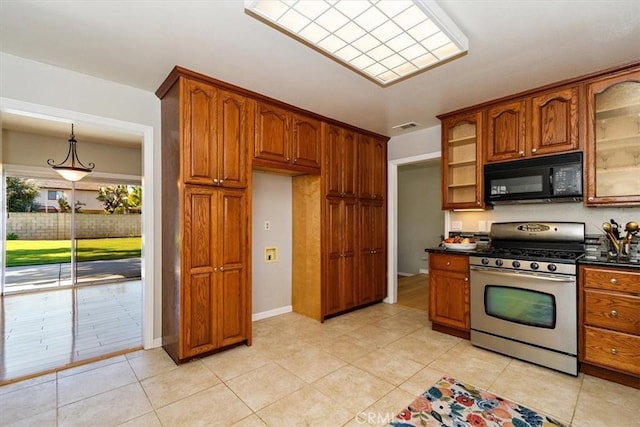 168 Radford Ct, Riverside, CA 92507 - kitchen featuring stainless steel gas range, black microwave, brown cabinets, glass insert cabinets, and dark countertops