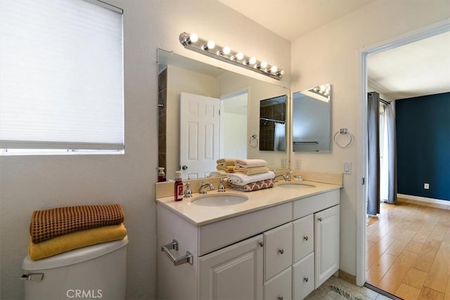168 Radford Ct, Riverside, CA 92507 - bathroom featuring double vanity, toilet, baseboards, and wood finished floors