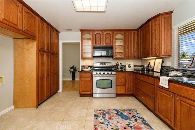168 Radford Ct, Riverside, CA 92507 - kitchen with gas range, black microwave, glass insert cabinets, and brown cabinetry