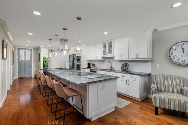 16422 Harbour Ln Unit 17, Huntington Beach, CA 92649 - kitchen featuring crown molding, tasteful backsplash, a breakfast bar, white cabinets, and recessed lighting