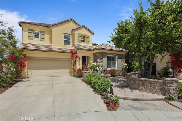 27086 Maple Tree Ct, Valencia, CA 91381 - view of front of home featuring an attached garage, a tiled roof, concrete driveway, stucco siding, and stone siding
