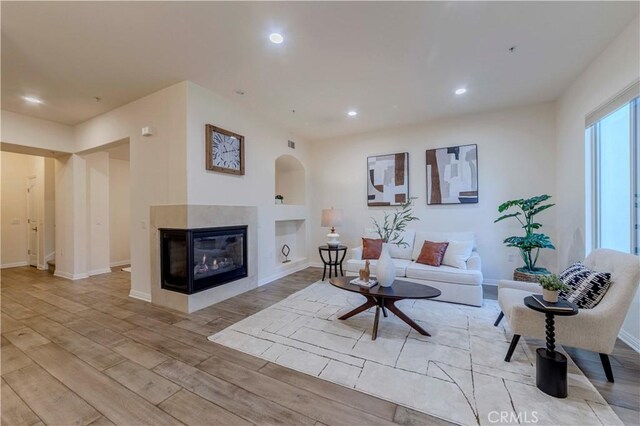 28220 Highridge Rd Unit 104, Rancho Palos Verdes, CA 90275 - living room with light wood-style flooring, a multi sided fireplace, baseboards, and recessed lighting