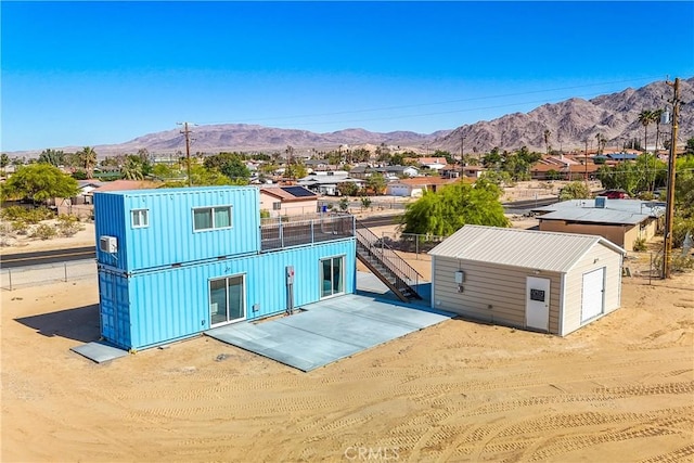 72473 Desert Trail Dr Unit 29, Palms, CA 92277 - view of front facade featuring a mountain view, stairs, an outdoor structure, and a patio area