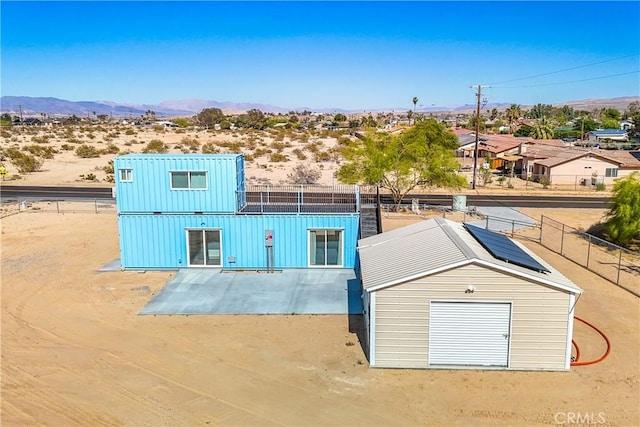 72473 Desert Trail Dr Unit 29, Palms, CA 92277 - view of front of house with board and batten siding, a mountain view, and fence