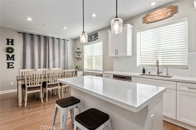 16073 Narni Ln, Fontana, CA 92336 - kitchen with a sink, tasteful backsplash, light wood-style flooring, white cabinets, and light countertops