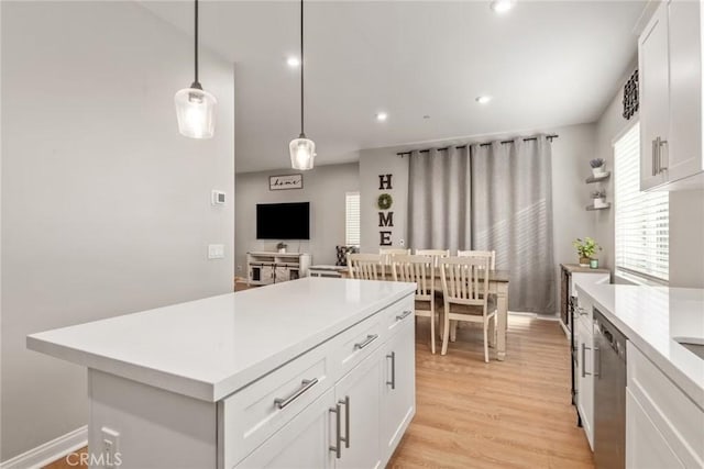 16073 Narni Ln, Fontana, CA 92336 - kitchen featuring dishwasher, light countertops, white cabinetry, light wood-style flooring, and pendant lighting