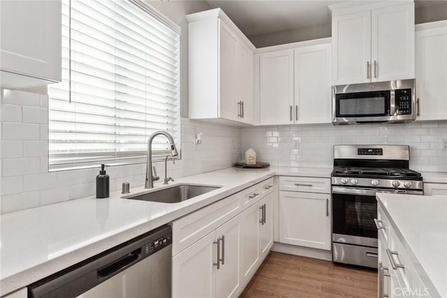 16073 Narni Ln, Fontana, CA 92336 - kitchen with stainless steel appliances, a sink, white cabinets, and light countertops