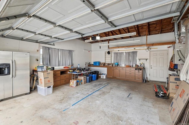 3631 Alta Vista Dr, Fallbrook, CA 92028 - garage featuring stainless steel fridge, a workshop area, and a garage door opener