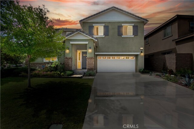 16759 Yellow Fern Ln, Fontana, CA 92336 - traditional-style home with an attached garage, concrete driveway, stucco siding, and a yard