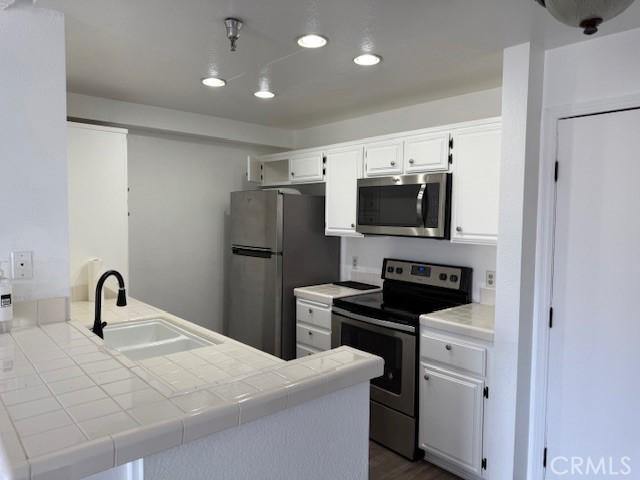 11410 Dolan Ave Unit 227, Downey, CA 90241 - kitchen featuring appliances with stainless steel finishes, a sink, tile countertops, a peninsula, and recessed lighting