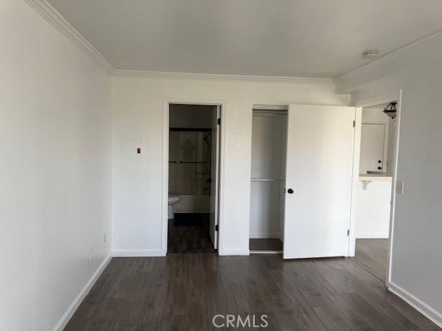 11410 Dolan Ave Unit 227, Downey, CA 90241 - unfurnished bedroom with baseboards, dark wood-style floors, crown molding, a closet, and connected bathroom