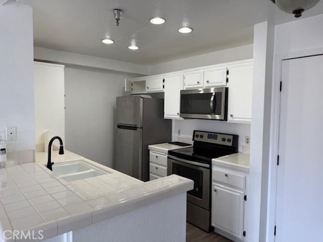 11410 Dolan Ave Unit 227, Downey, CA 90241 - kitchen featuring stainless steel appliances, a sink, tile countertops, a peninsula, and recessed lighting