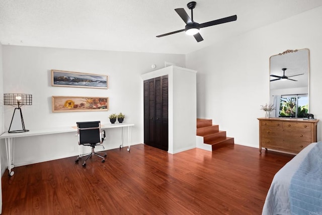 bedroom featuring wood finished floors, a desk, a ceiling fan, and a closet