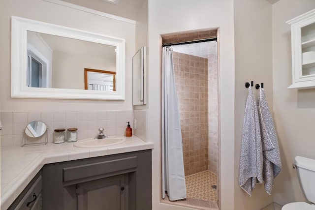 full bath featuring a shower stall, toilet, vanity, and tasteful backsplash