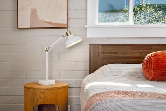 bedroom featuring concrete block wall