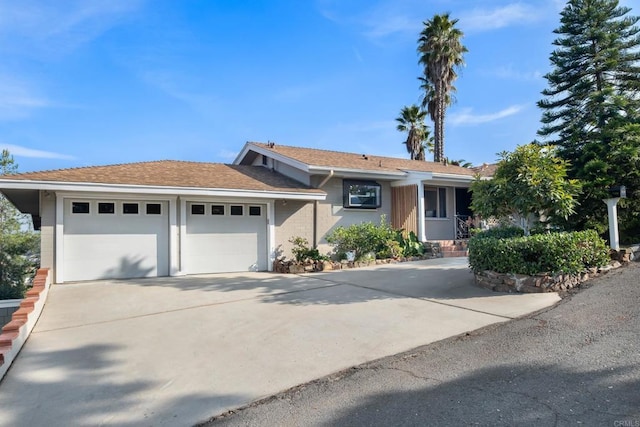 single story home with concrete driveway and a garage