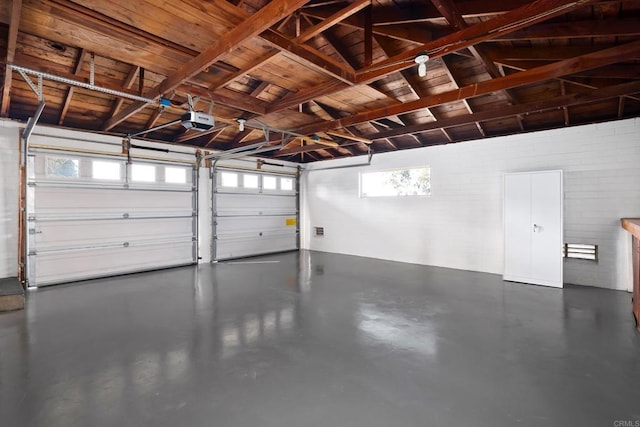 garage with a garage door opener and concrete block wall