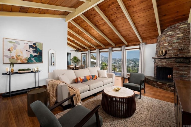 living area featuring wood finished floors, beam ceiling, wooden ceiling, a brick fireplace, and high vaulted ceiling