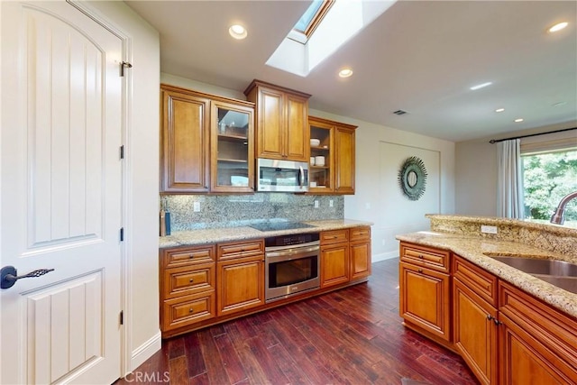 5595 Tanbark Ct, Avila Beach, CA 93424 - kitchen featuring appliances with stainless steel finishes, brown cabinetry, a sink, baseboards, and dark wood finished floors
