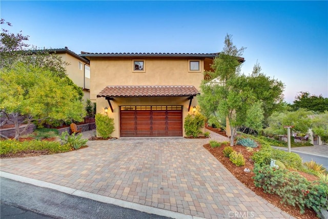 5595 Tanbark Ct, Avila Beach, CA 93424 - mediterranean / spanish home with decorative driveway, stucco siding, and an attached garage