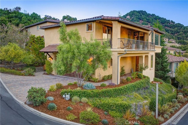 5595 Tanbark Ct, Avila Beach, CA 93424 - mediterranean / spanish-style house with a balcony, a tiled roof, stucco siding, driveway, and a mountain view