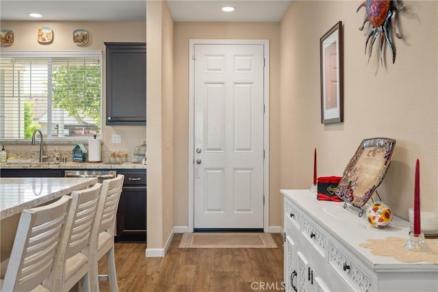 3293 Rogue River Dr, Chico, CA 95973 - kitchen featuring a sink, light wood-style floors, baseboards, recessed lighting, and light stone counters