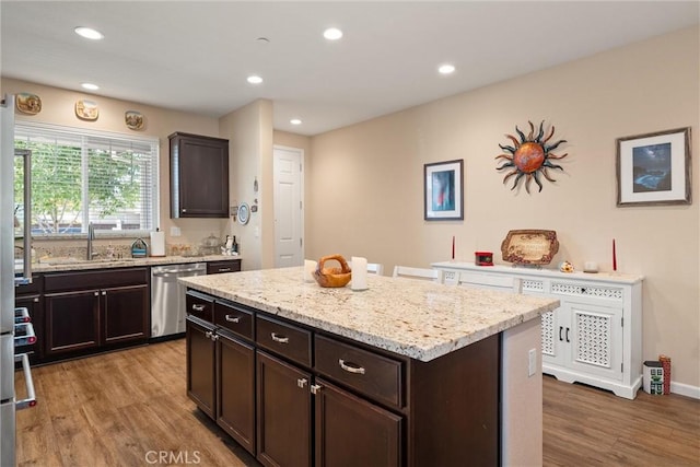 3293 Rogue River Dr, Chico, CA 95973 - kitchen featuring dishwasher, a sink, light wood-style floors, dark brown cabinets, and light stone countertops