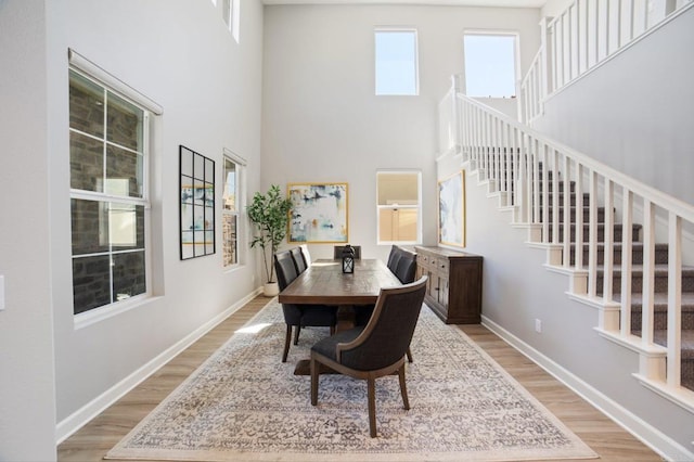 4650 Silent Knoll Dr, Fallbrook, CA 92028 - dining room with light wood-style floors, stairs, a towering ceiling, and baseboards