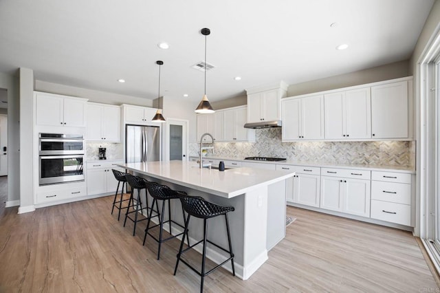 4650 Silent Knoll Dr, Fallbrook, CA 92028 - kitchen with appliances with stainless steel finishes, a sink, decorative backsplash, a breakfast bar, and an island with sink