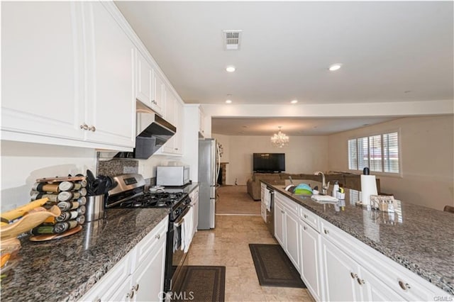 15590 Pumpkin Pl, Fontana, CA 92336 - kitchen with stainless steel appliances, a chandelier, open floor plan, white cabinetry, and dark stone countertops