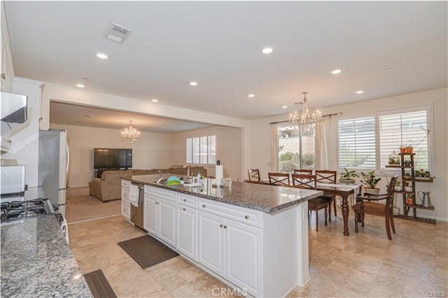 15590 Pumpkin Pl, Fontana, CA 92336 - kitchen featuring a chandelier, a sink, open floor plan, white cabinetry, and stainless steel dishwasher