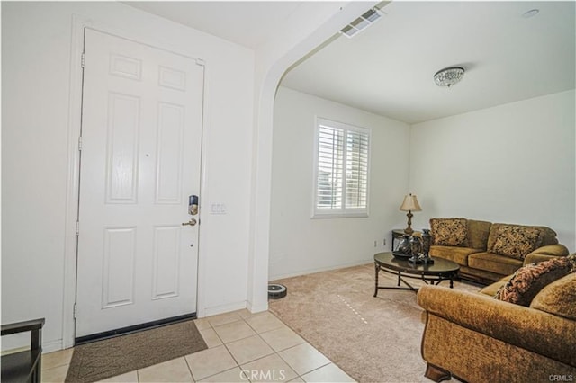 15590 Pumpkin Pl, Fontana, CA 92336 - living area featuring light tile patterned flooring, light carpet, baseboards, and arched walkways