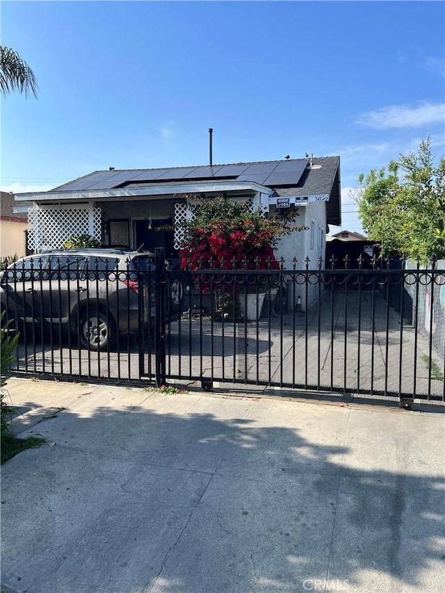 347 E 61st St, Los Angeles, CA 90003 - gate with a fenced front yard and roof mounted solar panels