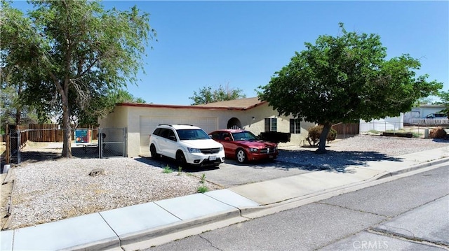 16582 Batson Rd, Victorville, CA 92395 - view of front of house featuring an attached garage, asphalt driveway, fence, and stucco siding