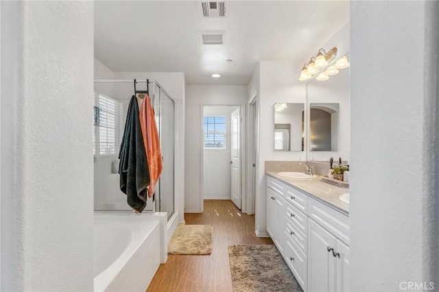 15070 Paseo Verde Pl, Victorville, CA 92394 - full bath featuring double vanity, a stall shower, wood finished floors, and a garden tub