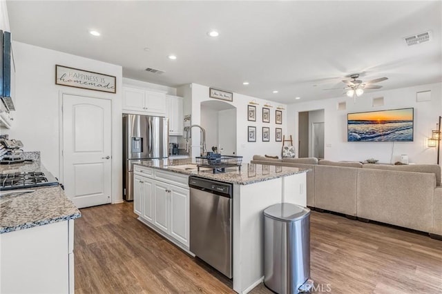 15070 Paseo Verde Pl, Victorville, CA 92394 - kitchen with stainless steel appliances, arched walkways, a sink, a ceiling fan, and white cabinets