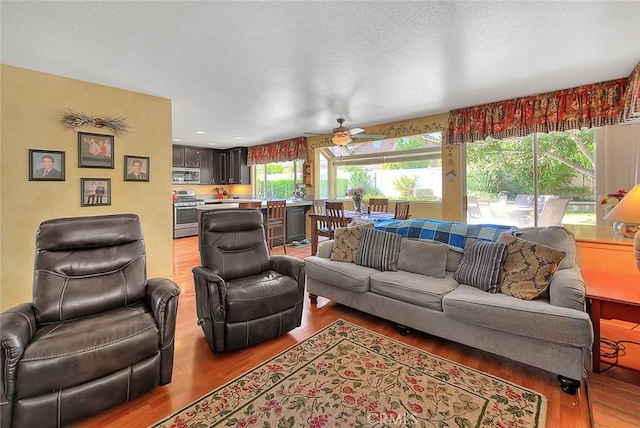 6730 Harrington Ct, Chino, CA 91710 - living area featuring wood finished floors, a ceiling fan, and a textured ceiling