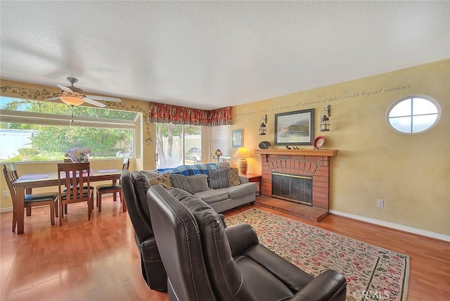 6730 Harrington Ct, Chino, CA 91710 - living area with wood finished floors, ceiling fan, a fireplace, baseboards, and a textured ceiling