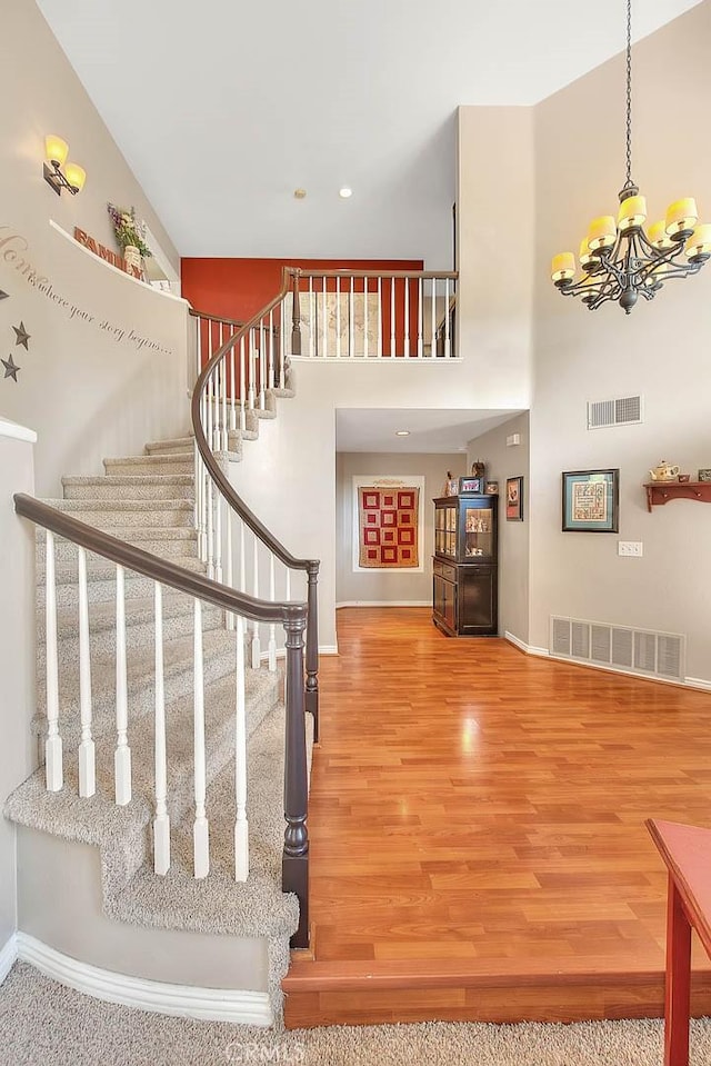 6730 Harrington Ct, Chino, CA 91710 - staircase featuring baseboards, wood finished floors, a towering ceiling, a chandelier, and recessed lighting