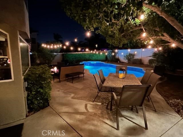 6730 Harrington Ct, Chino, CA 91710 - pool at night with a fenced backyard and a patio area